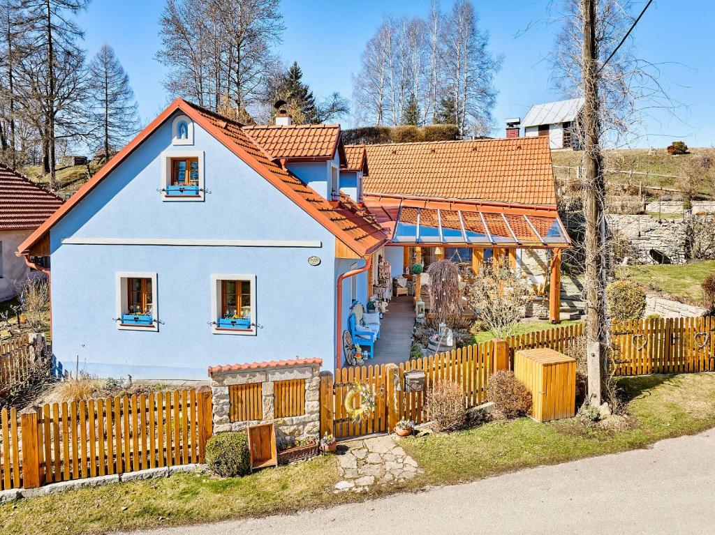 a house with an orange roof and a fence at Chaloupka Ovčárna in Jindrichuv Hradec