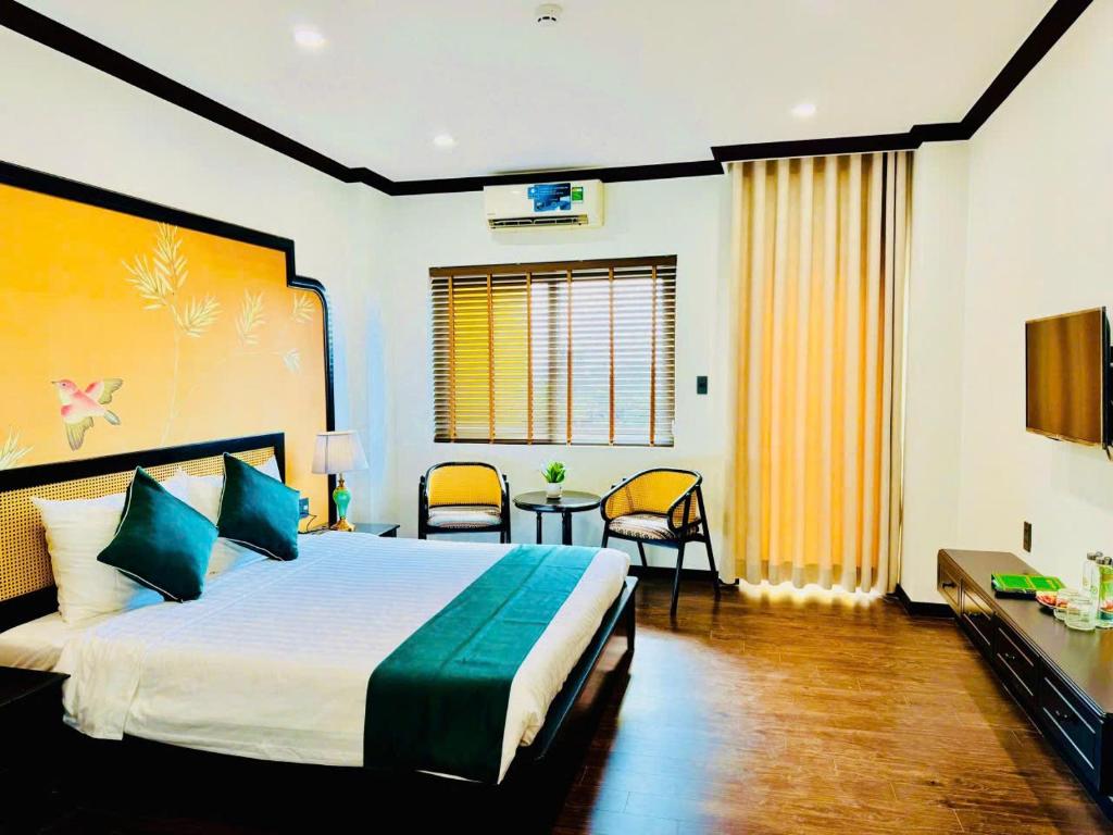 a bedroom with a bed and a table and chairs at Biet Dien Hotel in Buon Ma Thuot