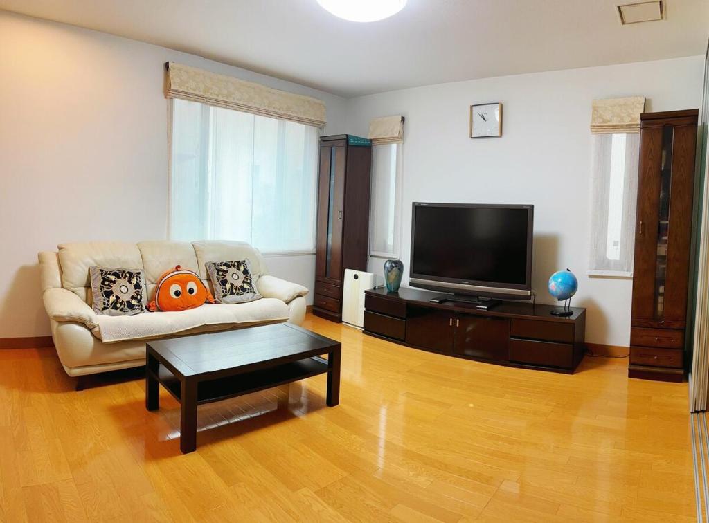 a living room with a couch and a flat screen tv at Aki House in Tokyo