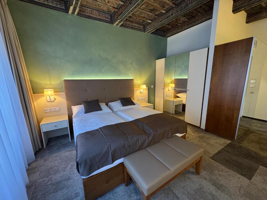 a bedroom with a large bed and two tables at The Golden Wheel Hotel in Prague