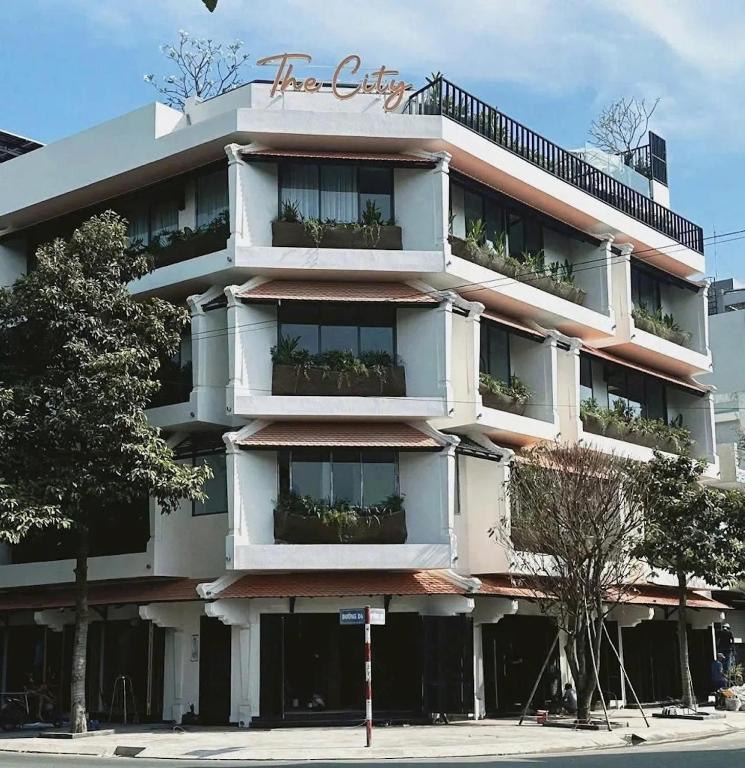a tall white building with plants on the balconies at The City Boutique Hotel in Bien Hoa