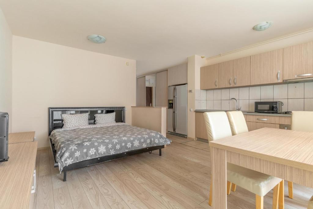 een slaapkamer met een bed en een tafel en een keuken bij City Oasis Studio in Oradea