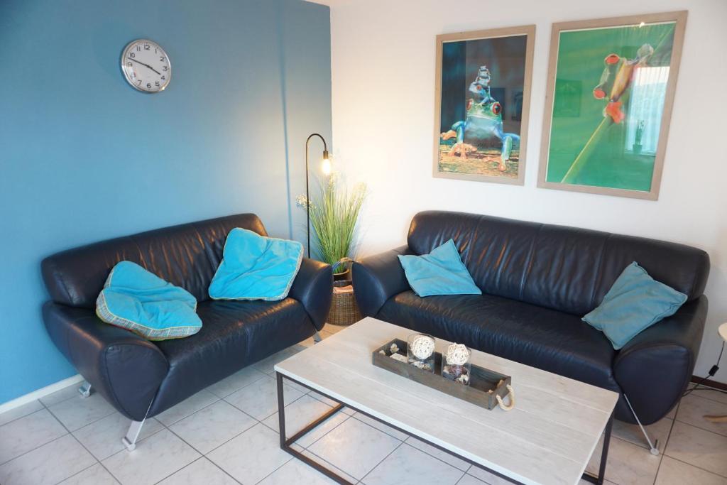 a living room with two leather couches and a coffee table at Kustverhuur , Park Scheldeveste, Zwin 143 in Breskens