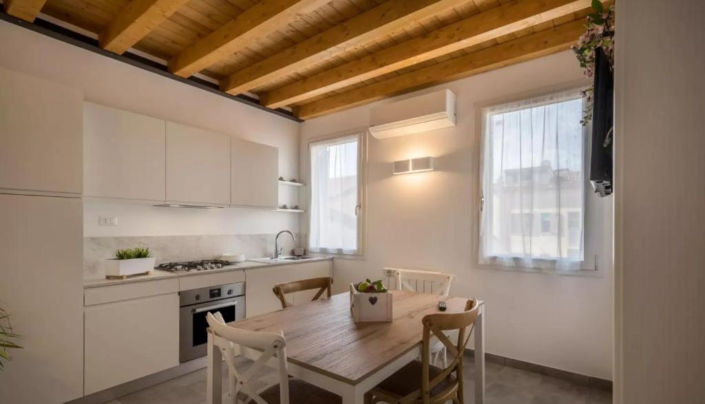 een keuken met een houten tafel en stoelen in een kamer bij Suite Laguna Sunset in Chioggia