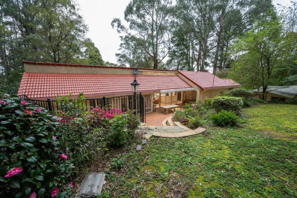 a small house with a red roof and a yard at Idaway Retreat in Olinda
