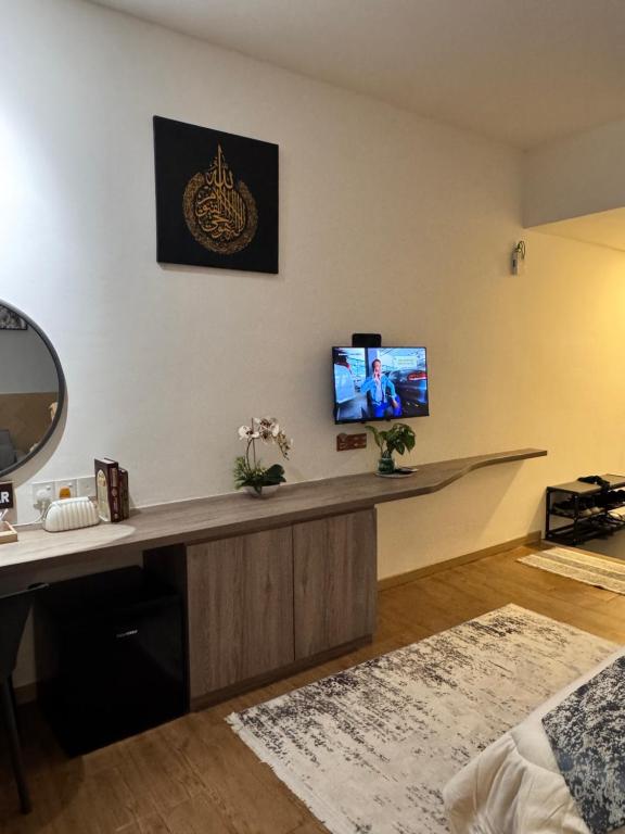 a living room with a tv on a wall at WANida Suite At Al Waqaf Resident Bandar Baru Tunjung in Kota Bharu