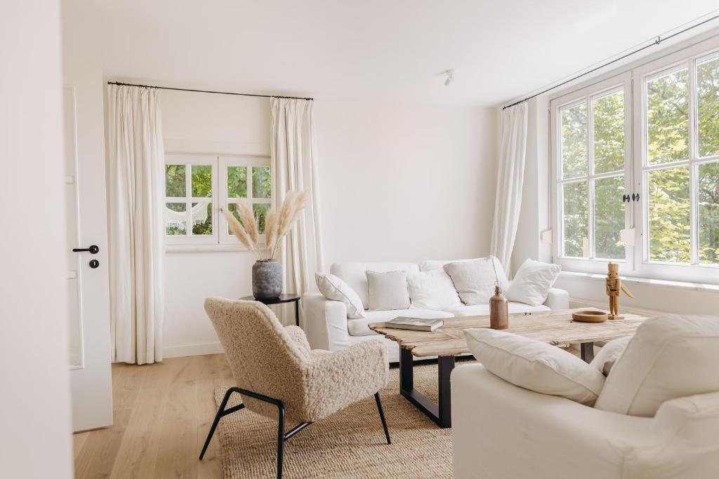 a living room with white furniture and a table at Waldmaise in Hayingen