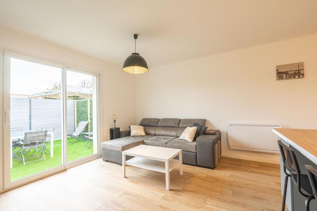 een woonkamer met een bank en een tafel bij L'instant fleuri in Saint-Hippolyte