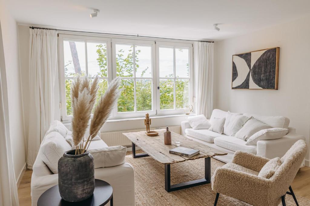 a living room with white furniture and a table at Waldmaise in Hayingen