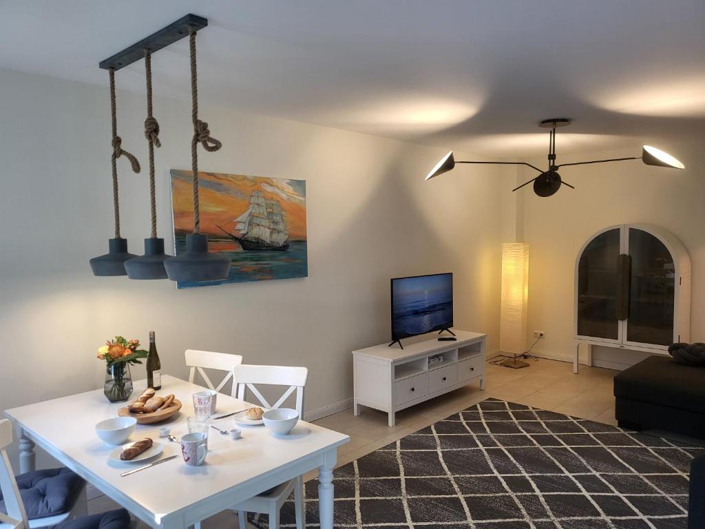 a living room with a white table and a tv at Böhler Haubarg Böhler Stuv 7 in Böhl