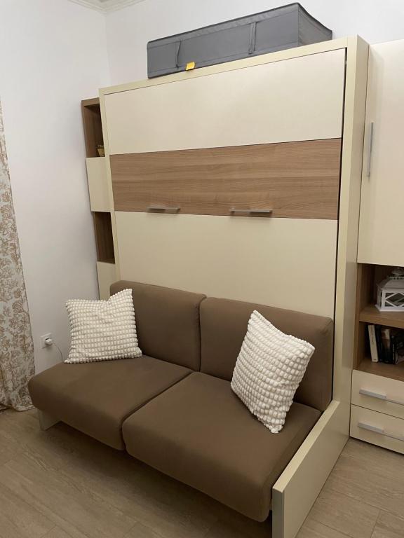 een bank met twee kussens erop in een kamer bij Appartement Vincennes cozy in Vincennes