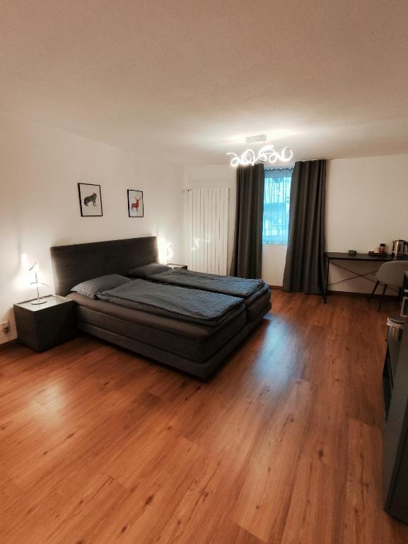 a bedroom with a bed and a wooden floor at B&B Berninapass Poschiavo Panorama in Poschiavo