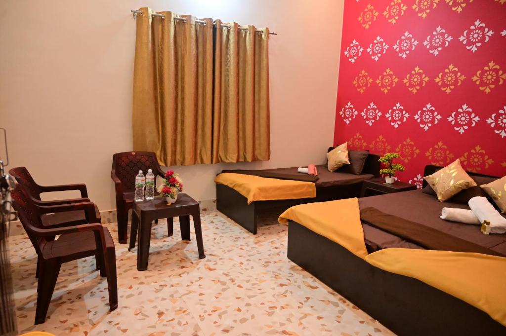 FaizābādOmkar Bhawan Home Stay的有两张床和一把椅子的酒店房间