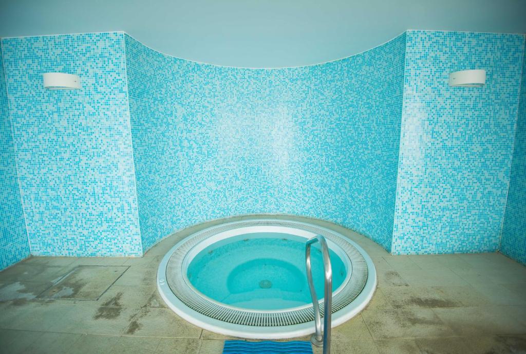 a blue tiled bathroom with a blue and white tub at Azoris Faial Garden – Resort Hotel in Horta