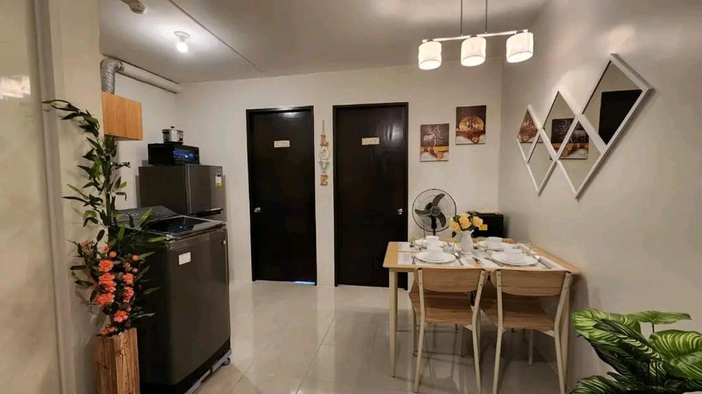 a dining room with a table and a kitchen at Ann Cozy Living in Cebu City