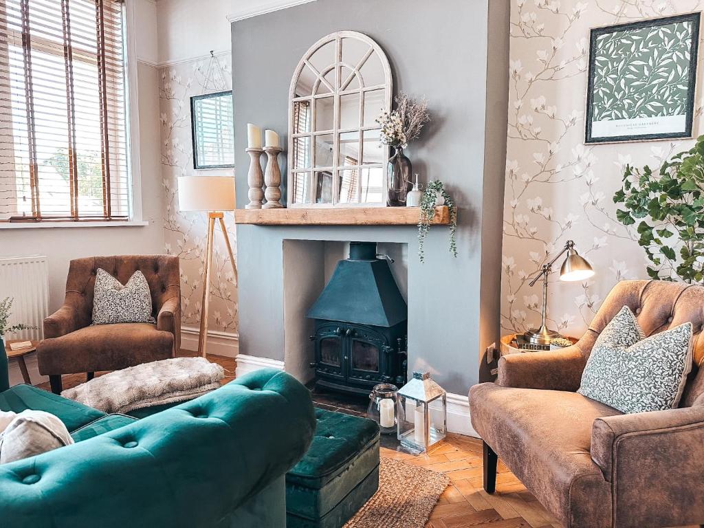 a living room with a blue couch and a fireplace at Ty-Fry House, by Solace Stays in Cardiff