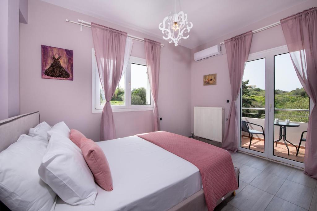 a bedroom with a bed and a balcony with a table at Green Hill Villa in Daratso
