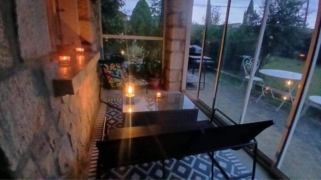 Grand Studio Côté Jardin في Saint-Sernin: غرفة مع شرفة وطاولة وشموع