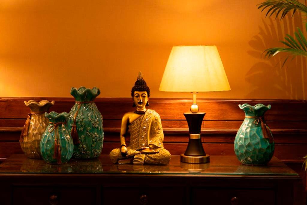 uma estátua sobre uma mesa ao lado de vasos em The Himalayan Residency em Duttnager