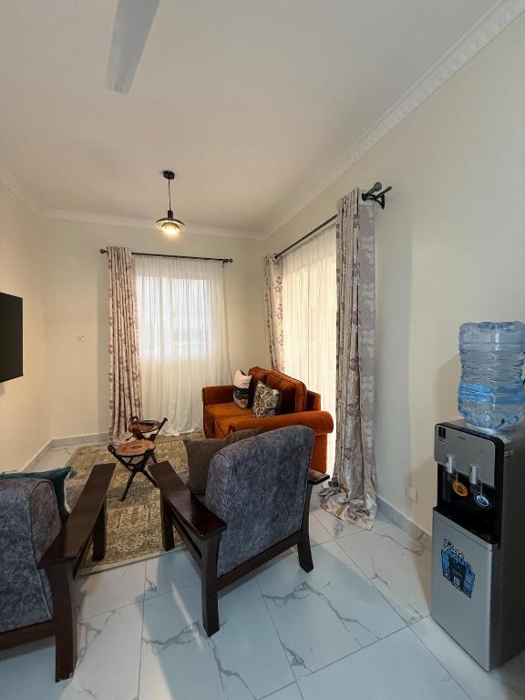 a living room with two chairs and a couch at Waridi is a modern, cosy penthouse in Mtwapa town in Mtwapa