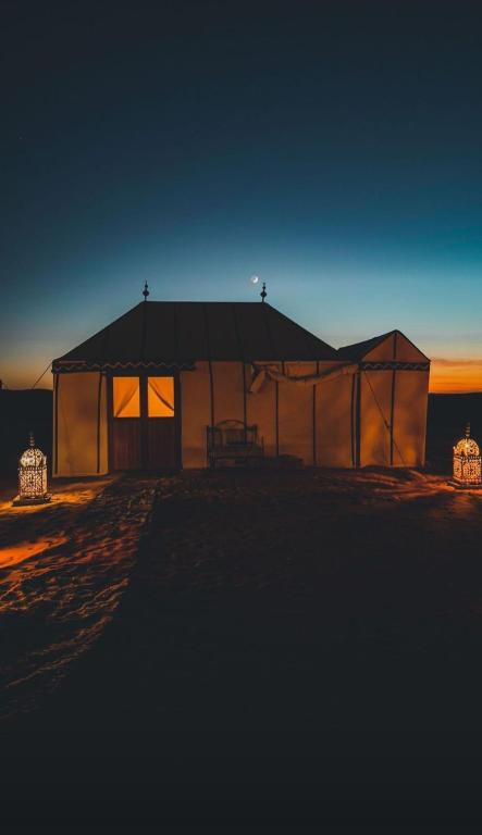a large tent with lights in front of it at night at Super Luxury camp in Merzouga