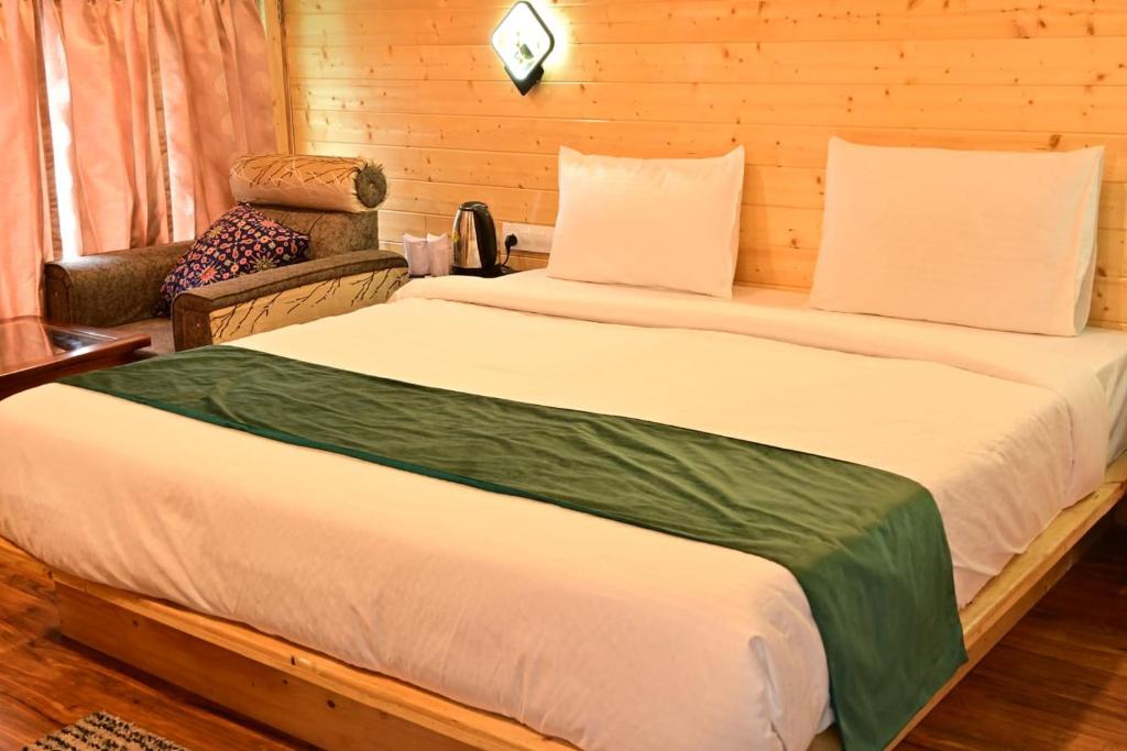 a bedroom with a large bed and a chair at Hotel DS Villa in Zirakpur