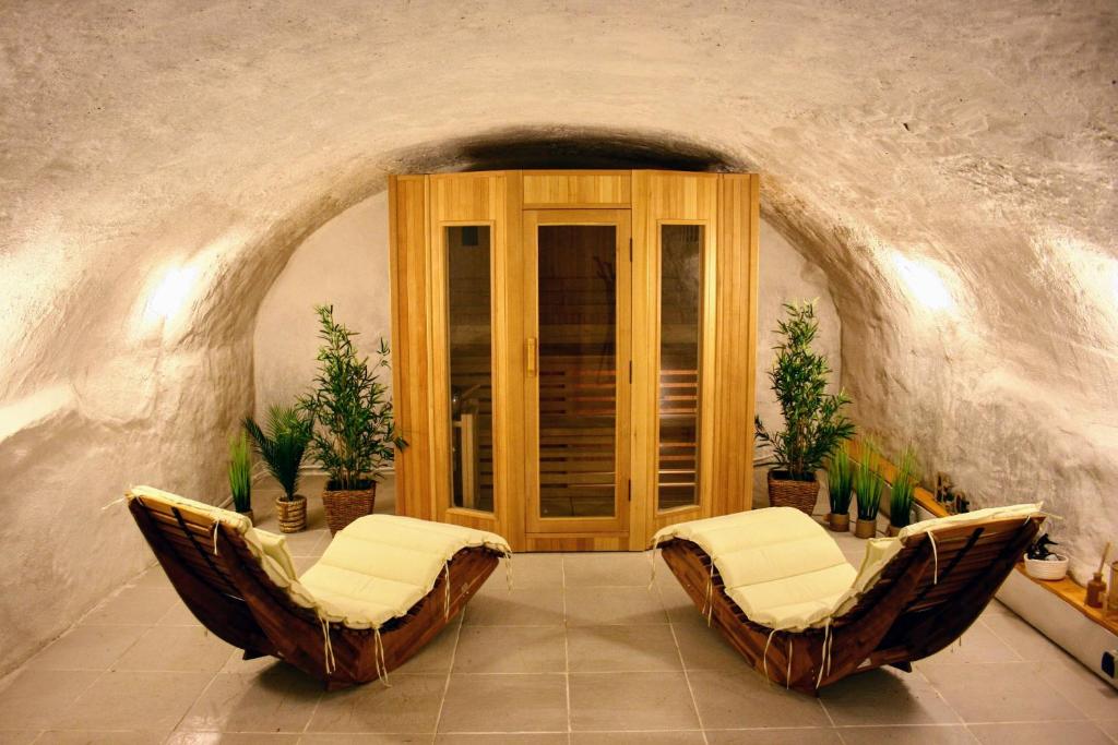 ein Wohnzimmer mit 2 Stühlen und einer Tür in der Unterkunft Chalet Bois 6 personnes Sauna et Gym in Bellecombe