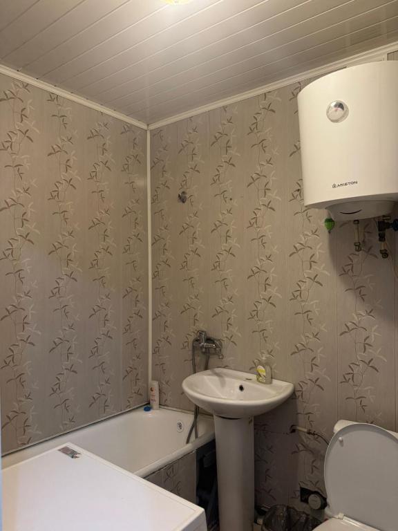 une salle de bain avec un lavabo, des toilettes et une baignoire dans l'établissement Однокомнатая квартира, à Kökşetaw