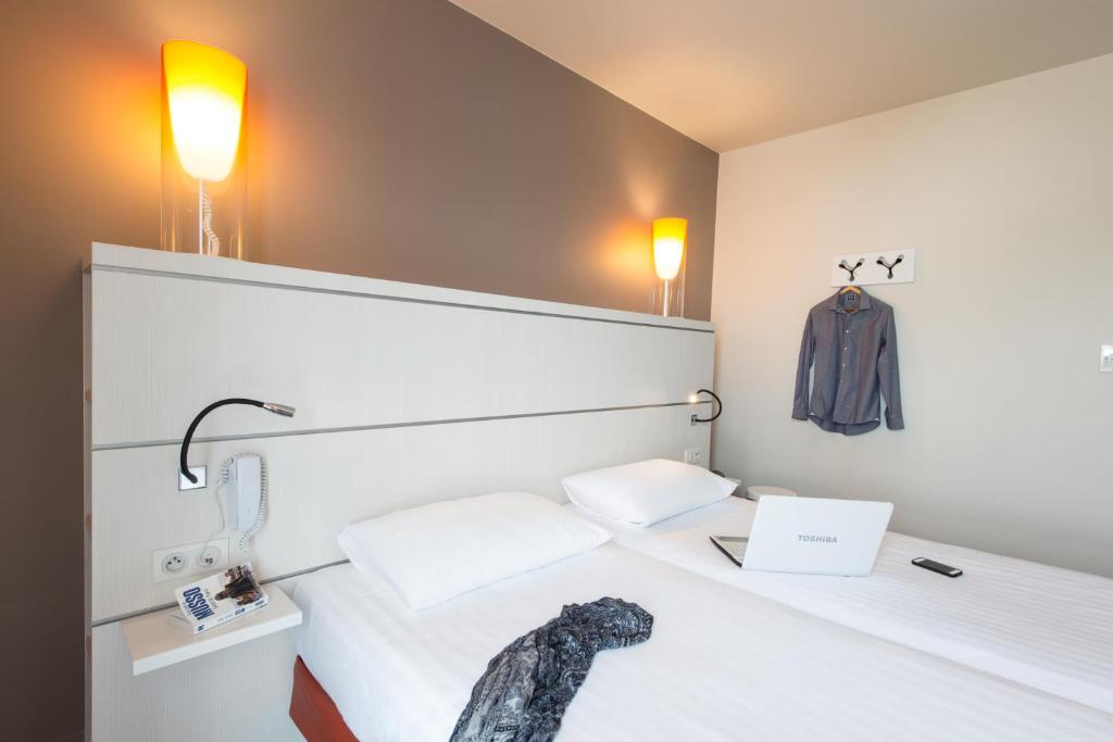 Un ou plusieurs lits dans un hébergement de l'établissement Hôtel Confort La Rochelle Centre les Minimes