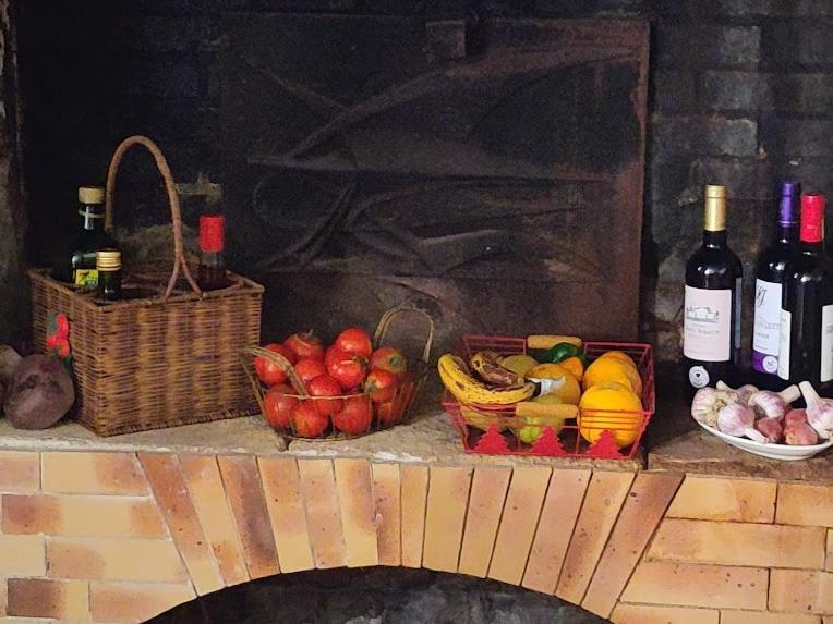 - une table avec des paniers de fruits et des bouteilles de vin dans l'établissement L'envol, à Germond