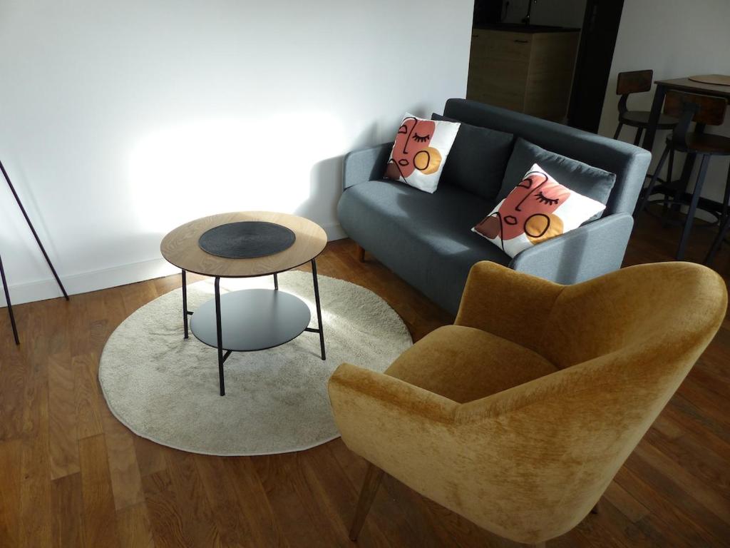 un salon avec un canapé et une table dans l'établissement Appartement cozy, à Pleine-Fougères