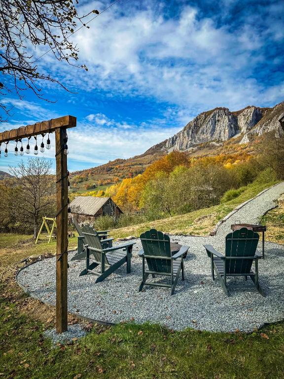 three chairs and a table on a gravel road at Greta Hillside in Buceş-Vulcan