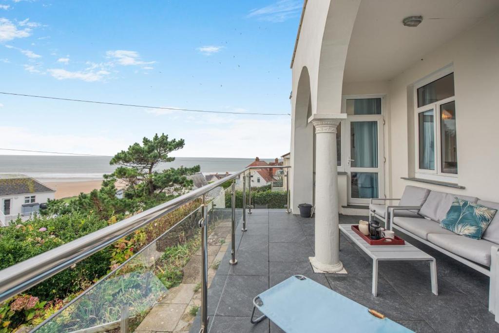 a balcony with a couch and a view of the ocean at Francis Cottage in Woolacombe
