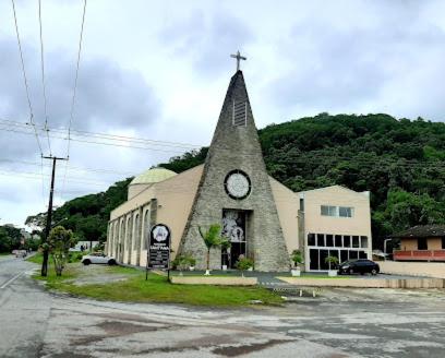 a church with a steeple with a clock on it at Praia e Sol em Caiobá! in Matinhos