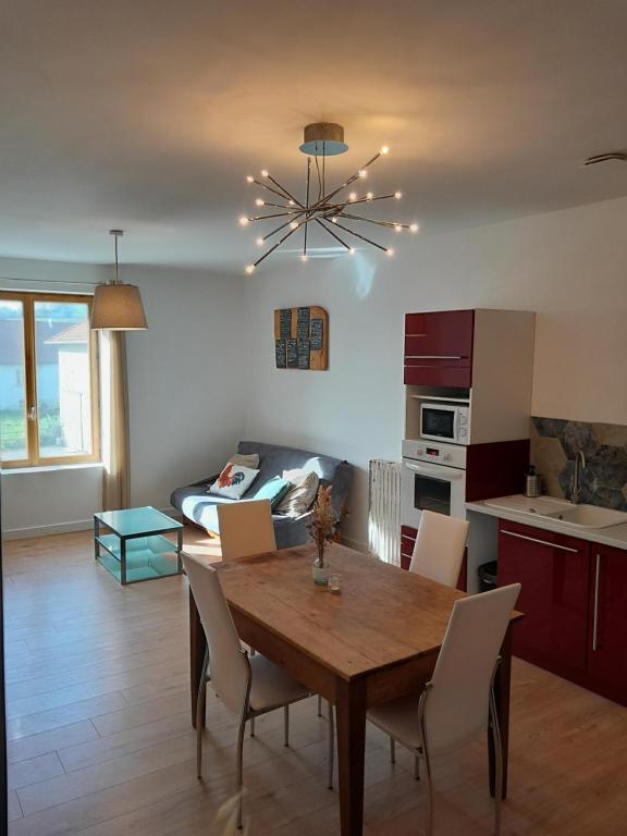 a kitchen and dining room with a table and chairs at Logement indépendant au cœur d'une ferme in Blandin