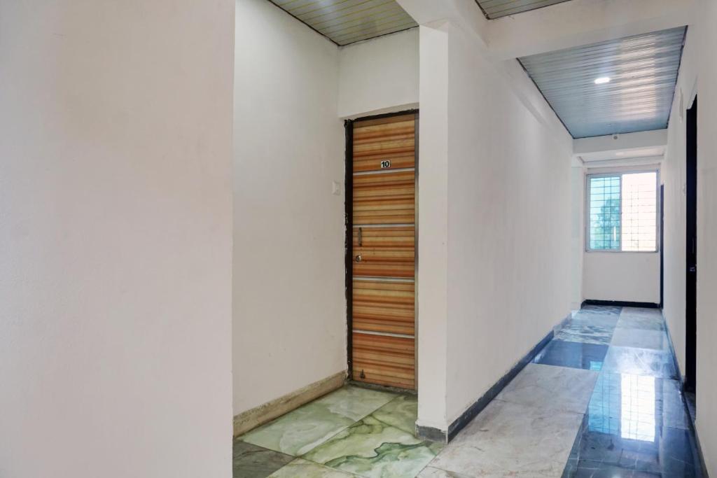 PhūrsungiにあるCollection O Aachal Hotel & Lodgingの建物内の木製のドアのある廊下