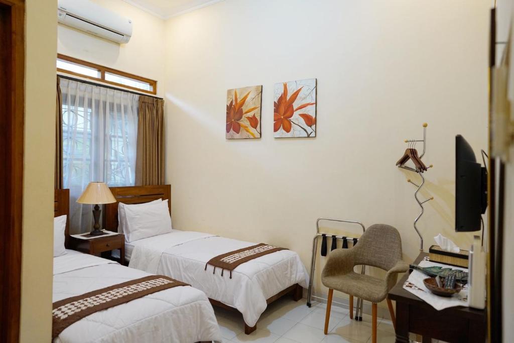 Ένα ή περισσότερα κρεβάτια σε δωμάτιο στο Ndalem Panembahan 12 Guest House