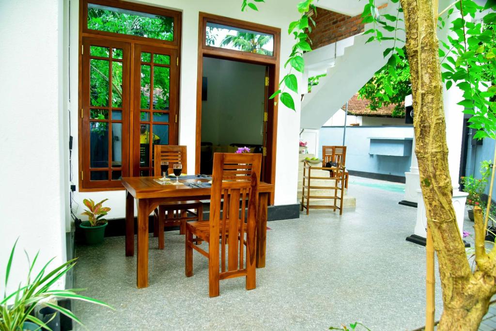 a dining room with a wooden table and chairs at KK City Villa in Aluthgama