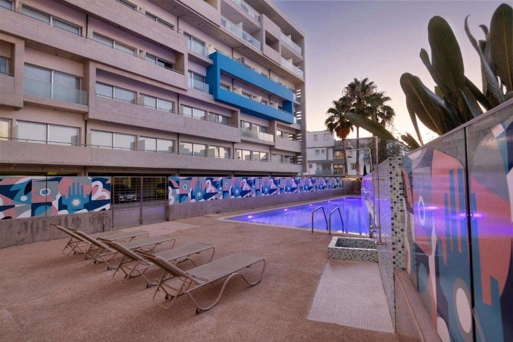 a swimming pool in a building with two benches and a swimming pool at UC Hall Residence in Nicosia