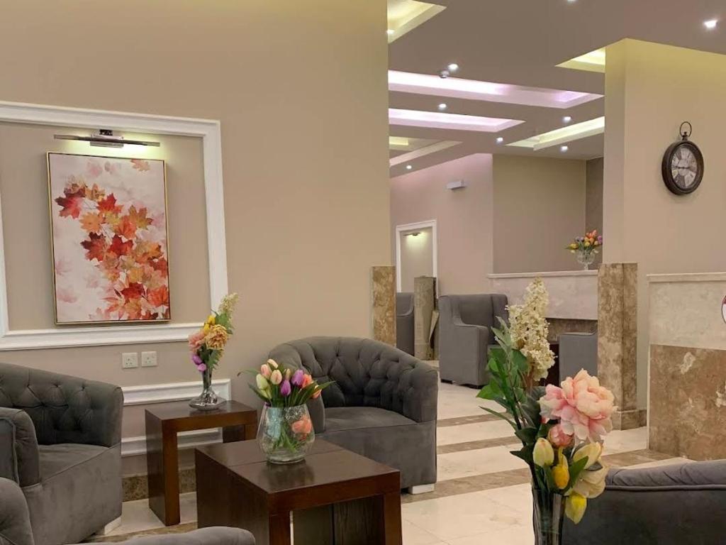 a waiting room with couches and tables and flowers at ورد للشقق المخدومة - احد رفيدة in Ahad Rafidah