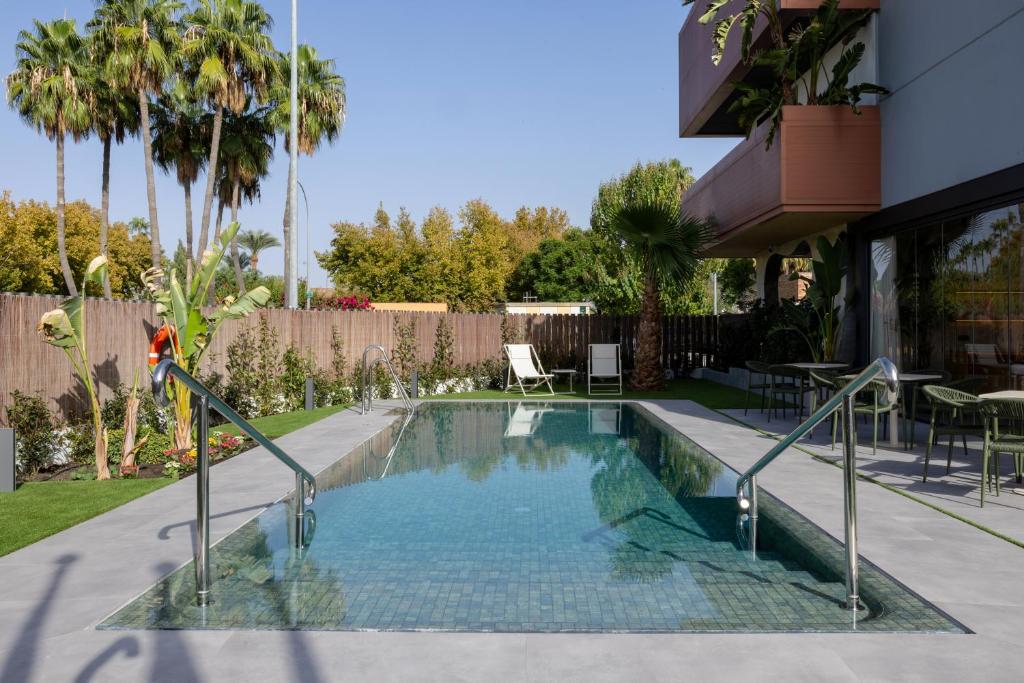 a swimming pool in the backyard of a house at Sevilla Green Suites in Alcalá de Guadaira