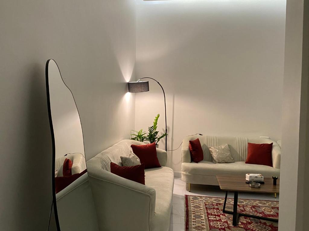 a living room with a couch and a lamp at شقق المصيف الفندقيه in Hafr Al Baten