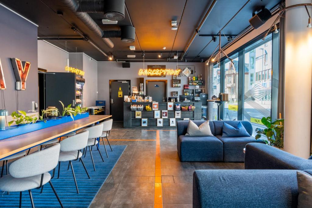 a bar with chairs and a couch in a room at Comfort Hotel Xpress Tromsø in Tromsø