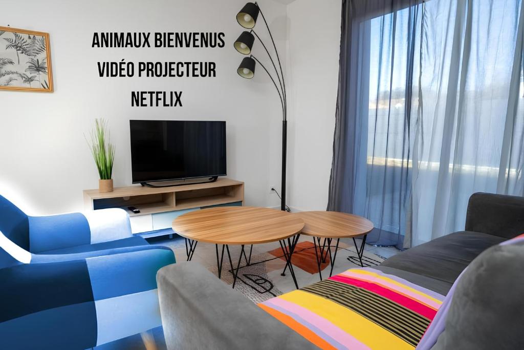 a living room with a couch and a table and a tv at La Maison Turquoise in Giroussens