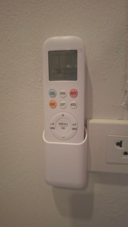 a white remote control hanging on a wall at Chamim Apartments Koh Lanta ชามิม in Phra Ae beach