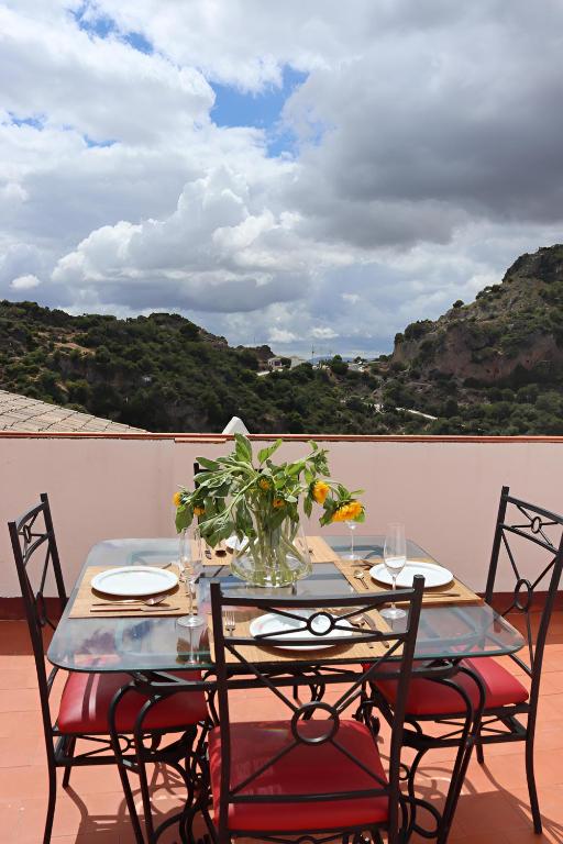 a table with chairs and a vase of flowers on a patio at La Casa Colores in Casares