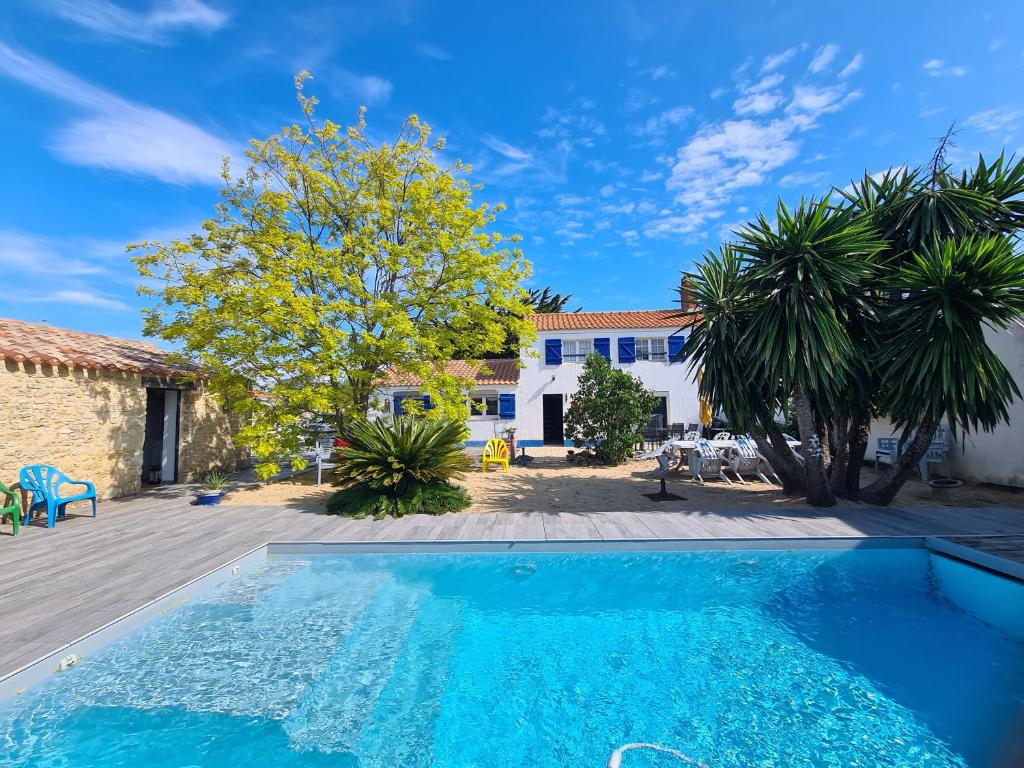 a swimming pool in front of a villa at Maison sur Ile de Noirmoutier in LʼÉpine