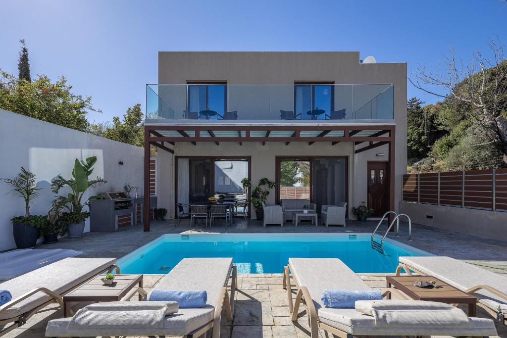 a villa with a swimming pool and a house at Villa Fotinou Heated Pool & Free Bikes awaits in Fotinós