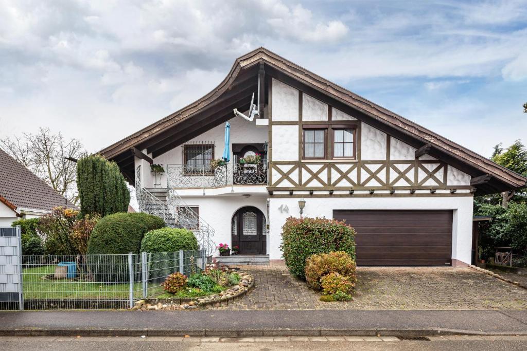 a white house with a fence in front of it at Ferienwohnung Hufenus in Breisach am Rhein