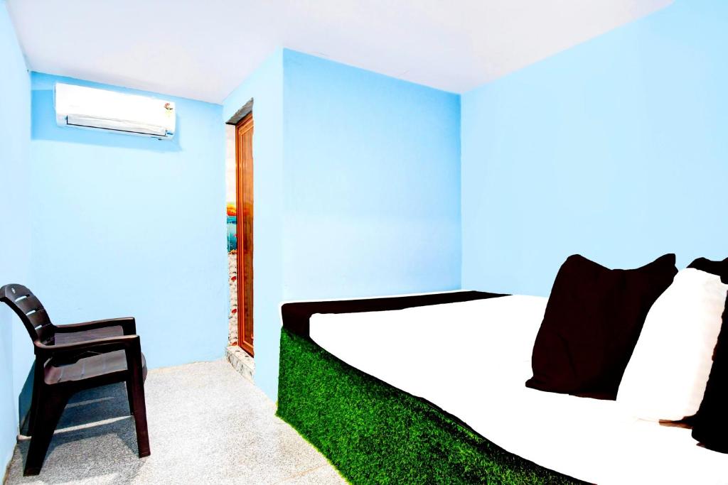 Un dormitorio azul con una cama y una silla. en Hotel #Shreeeee Krishnaaaaa# Near रेलवे स्टेशन, en Bhubaneshwar
